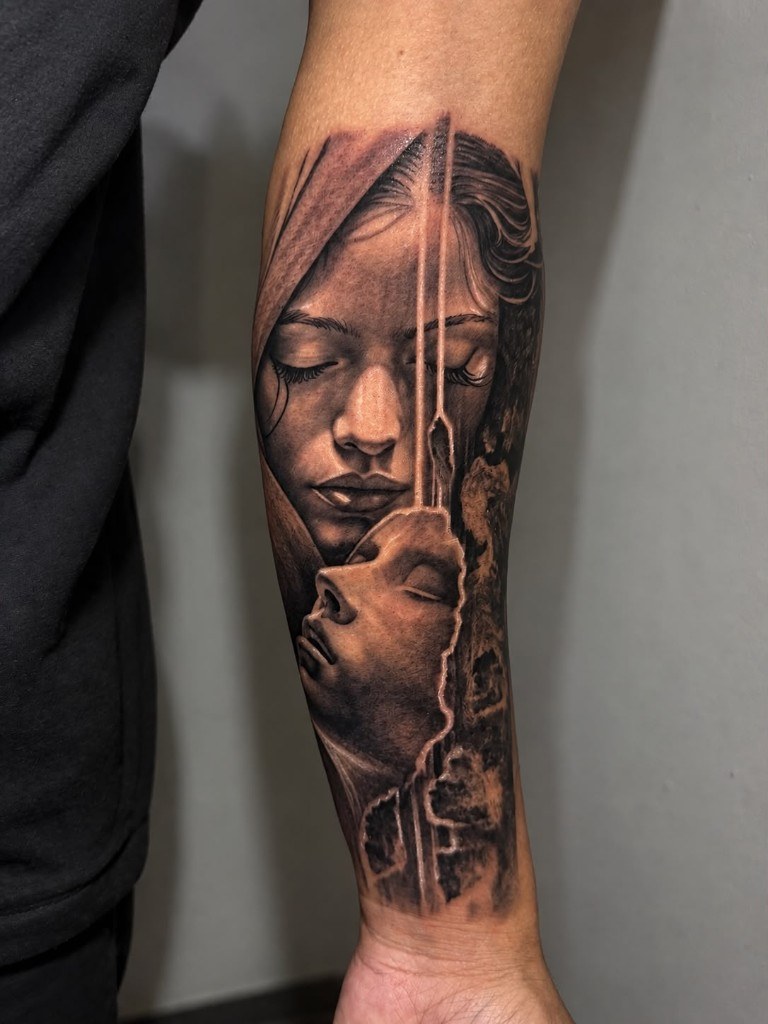 Black and grey realism tattoo with two portrait faces on forearm